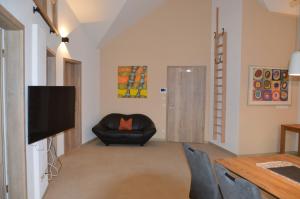 TV a/nebo společenská místnost v ubytování Ferienwohnung, 2 Zimmer, 4 bis 6 Personen, 67 qm, mit großem Balkon, entlang am Fluss, an der Aach, am Bodensee, nah am Naturschutzgebiet