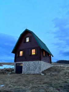 una casa con tejado abuhardillado en un campo en Topli Dom Golija, en Radaljica