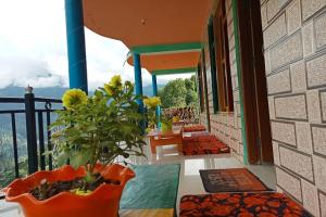 a balcony with a table and a plant on it at Hotel O Snow Pine Guest House Tosh in Manīkaran +17 photos