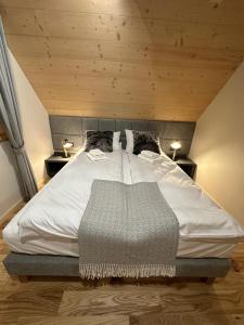 a bedroom with a large white bed with wooden ceilings at Tatra Wood House Boutique in Zakopane