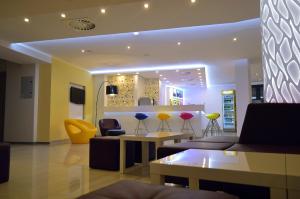 a living room with a couch and chairs and a bar at Arena Mar Hotel and SPA in Golden Sands