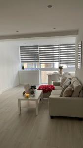 Apartamento Arena Benidorm في بنيدورم: غرفة معيشة مع أريكة وطاولة