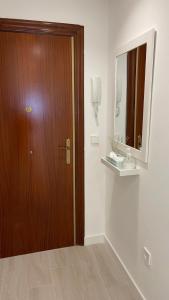 a bathroom with a wooden door and a mirror at Apartamento Arena Benidorm in Benidorm