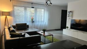 uma sala de estar com um sofá e uma televisão em FeWo Souterrain TT-Bodensee em Tettnang