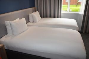 two white beds in a hotel room with a window at Holiday Inn Express Canterbury by IHG in Canterbury