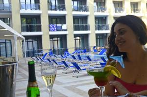 a woman sitting at a table with a banana at Arena Mar Hotel and SPA in Golden Sands
