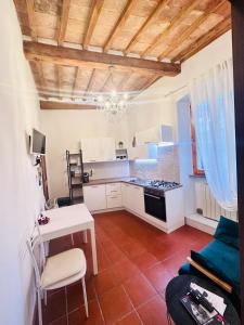 a kitchen with white cabinets and a table and a stove at Il cretto bianco in Città di Castello