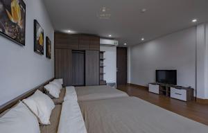 a bedroom with a large bed and a flat screen tv at L’amour homestay n cafe in Thôn Kim Long (1)
