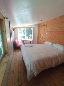 Un dormitorio con una cama grande y una ventana en La Frontera Bed & Breakfast, Valle Cochamó, en Cochamó