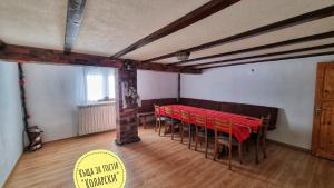 una stanza con una fila di tavoli e sedie rossi di Къща за гости Коларски a Sapareva Banya