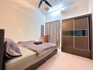 um quarto com uma cama e uma grande cómoda em TAMAN UNIVERSITI THREE BEDROOMS 6-10Pax UTM, SKUDAI em Skudai