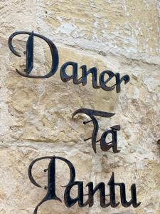 a sign that says bandanaana amuna on a stone wall at Daner Ta’ Pantu House in Kerċem