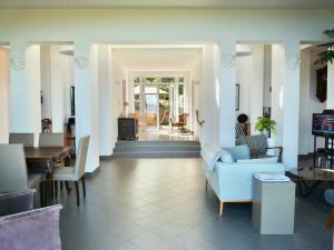 ein Wohnzimmer mit einem blauen Sofa und Stühlen in der Unterkunft Corse Piana villa d’architecte vue exceptionnelle in Piana