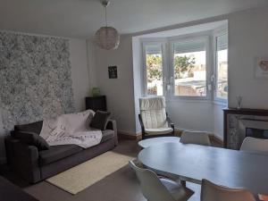 uma sala de estar com um sofá e uma mesa em Appartement 4 voyageurs - Proche plage em Bray-Dunes