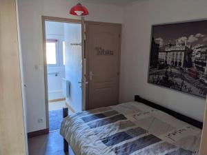 um quarto com uma cama e uma fotografia na parede em Appartement 4 voyageurs - Proche plage em Bray-Dunes
