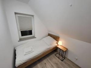 niewielka sypialnia z łóżkiem i oknem w obiekcie Sosnowe Wzgórze - Wypoczynek w Zagórzu Śląskim 2 w Zagórzu Śląskim