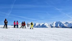 um grupo de pessoas em pé no topo de uma montanha coberta de neve em Gasthof Geronimo em Weissbach bei Lofer