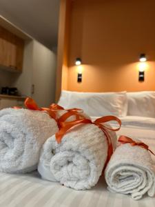 duas toalhas numa cama num quarto de hotel em Orange Luxury apartment in agrinio em Agrinion