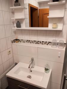 een witte badkamer met een wastafel en een spiegel bij Haus Sonntal in Bodenmais