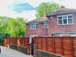 uma casa de tijolos com uma cerca de madeira em frente em Space House em Sheffield