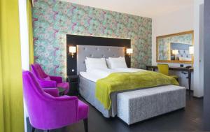 a bedroom with a bed and two purple chairs at Thon Hotel Opera in Oslo +37 photos