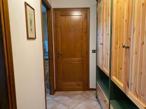 einen Flur mit Holztür in einem Haus in der Unterkunft [App. Tremol] 50 mt da piste sci in Piancavallo