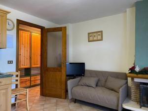 a living room with a couch and a television at [App. Tremol] 50 mt da piste sci in Piancavallo