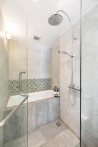 La salle de bains est pourvue d'une douche et d'une baignoire. dans l'établissement MIQ Ekkamai1 - 5BR house 65 inch TV, à Bangkok
