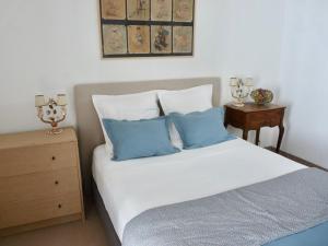 ein Schlafzimmer mit einem Bett mit blauen und weißen Kissen in der Unterkunft Corse Piana villa d’architecte vue exceptionnelle in Piana