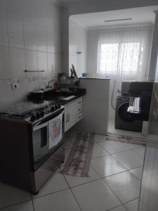 a kitchen with a stove and a sink in it at Ap 1 dormitório Praia Grande(canto do forte) 100m da praia in Praia Grande