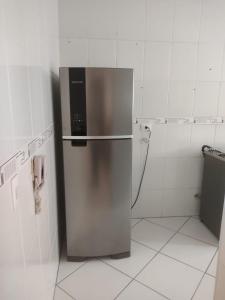 a stainless steel refrigerator in a white kitchen at Ap 1 dormitório Praia Grande(canto do forte) 100m da praia in Praia Grande