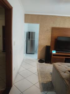 a living room with a couch and a refrigerator at Ap 1 dormitório Praia Grande(canto do forte) 100m da praia in Praia Grande