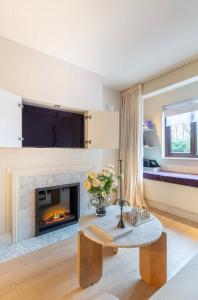 a living room with a fireplace and a table at Spring Stays Cosy 2-Bed Residence with Free Parking in London