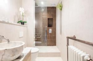 W łazience znajduje się umywalka, toaleta i prysznic. w obiekcie Spring Stays Cosy 2-Bed Residence with Free Parking w Londynie