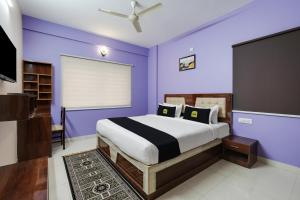 um quarto com paredes roxas e uma cama grande em Super Collection O Veritas Grand em Bangalore