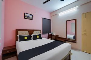 1 dormitorio con 1 cama grande y espejo en Super Collection O Veritas Grand, en Bangalore