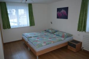 ein Schlafzimmer mit einem Bett in einem Zimmer in der Unterkunft Haus Amasaas in Saas-Fee