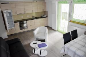eine Küche mit einem weißen Stuhl und einem Tisch in der Unterkunft Haus Amasaas in Saas-Fee