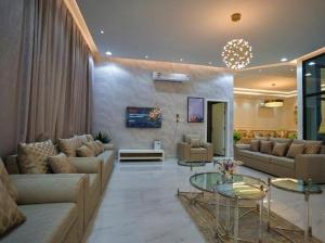 een grote woonkamer met banken en een tafel bij شاليهات لاڤيرا in Hafr Al Baten