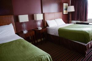 een hotelkamer met 2 bedden en 2 lampen bij Relax Inn in Collinsville