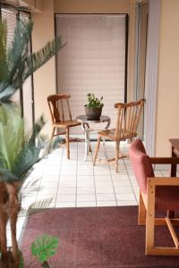 a porch with two chairs and a table and a plant at Relax Inn in Collinsville