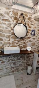 baño con lavabo y pared de piedra en Latipik, en Lançon-Provence