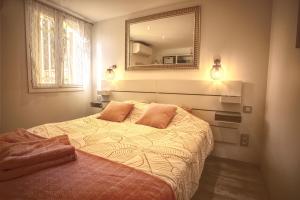 a bedroom with a bed with a mirror on the wall at A1 LA PLAGE D'OR in Le Lavandou