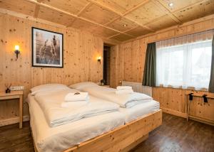 een slaapkamer met 2 bedden in een houten kamer bij AURA Bed & Breakfast in Sankt Jakob in Defereggen