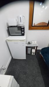eine Küche mit einer Mikrowelle auf dem Kühlschrank in der Unterkunft Cosy and Relaxing in Chatham