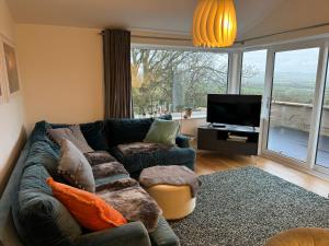 a living room with a couch and a tv at The Lookout in Wedmore