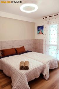 a bedroom with a large bed with two towels on it at Blue Sky Berlin - Passeig Jaume I in Salou
