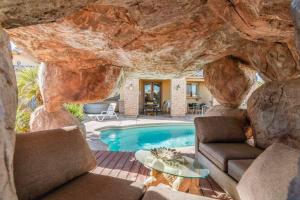 uma sala de estar com uma piscina e uma parede de pedra em Dream Villa em Las Vegas