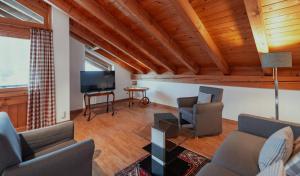 a living room with a couch and chairs and a tv at Ferienhaus Riss in Bolsterlang