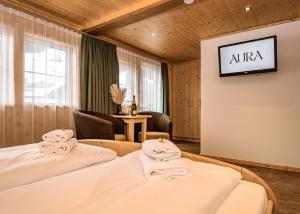 two beds in a room with a tv on a wall at AURA Bed & Breakfast in Sankt Jakob in Defereggen